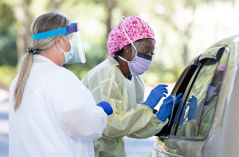 Two BayCare team members working with a patient at a drive through testing center