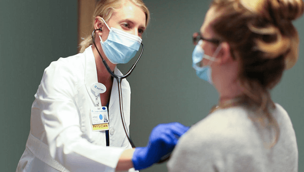 Physician examining a patient in a mask