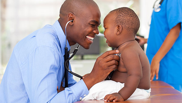 A doctor examines a toddler boy.