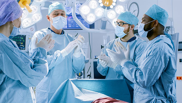 A group of surgeons are clapping after a surgery