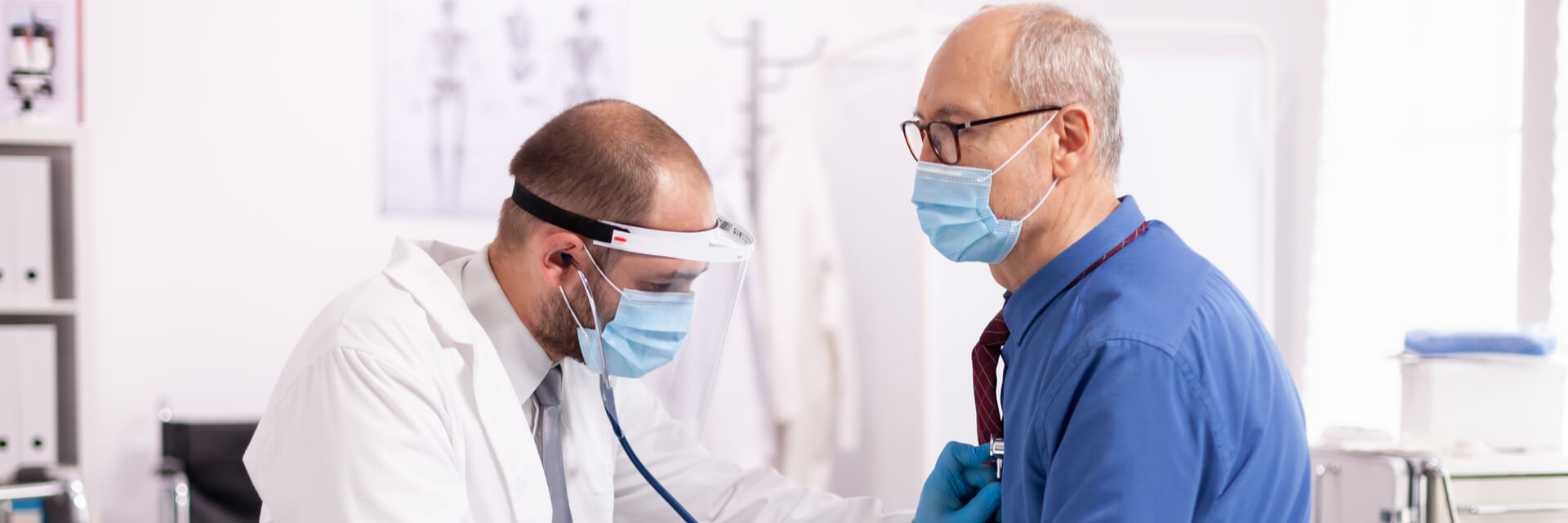 Doctor examining patient lungs using stethoscope wearing face mask