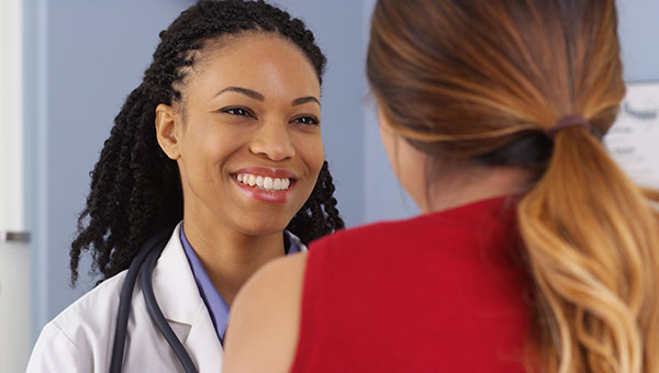 A woman doctor talks with a patient.