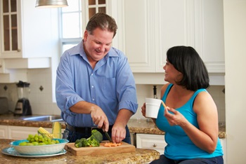 A man and woman preparing a healthy meal with plenty of vegetables