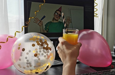 People are celebrating a birthday remotely via videoconference during the COVID-19 pandemic.