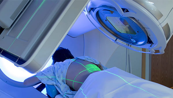 A patient lies on her stomach while receiving radiation therapy at a cancer treatment center.