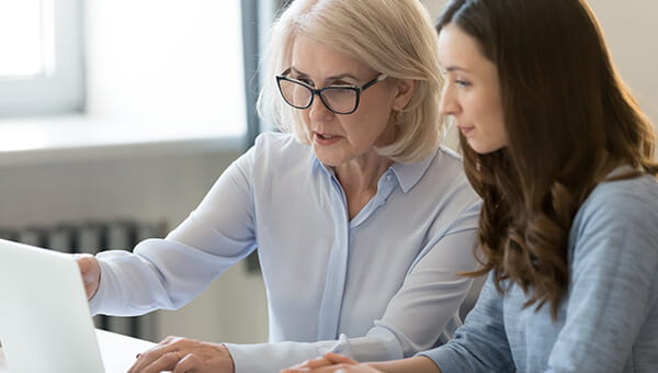Two women look at a computer screen