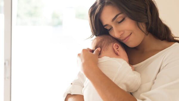 A mother is holding her newborn baby.