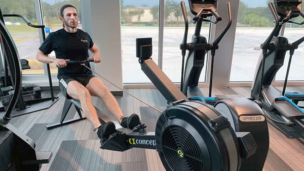 Trainer using Bloomingdale Fitness Center Rowing Machine
