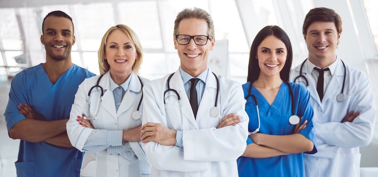 a team of medical professionals smiling with arms crossed