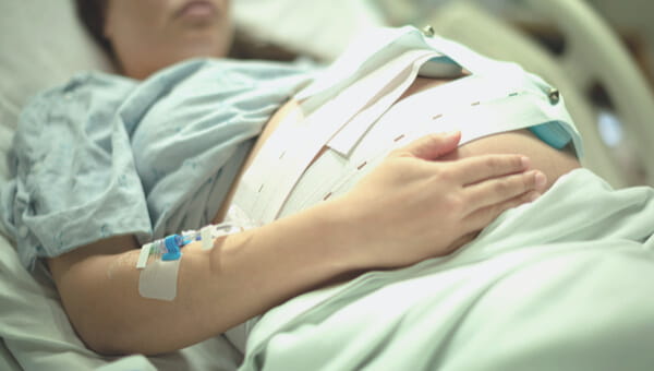 a woman in a hospital bed with an iv in her arm